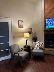 塞多纳Family Friendly Home with Character and Charm的客厅配有两把椅子、一盏灯和电视