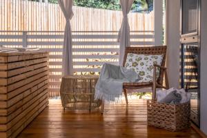 弗尔萨尔Camping Resort Tina Vrsar的门廊设有摇椅和围栏
