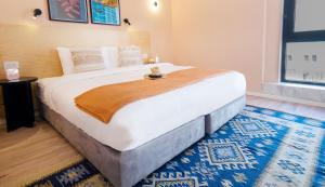 特拉维夫Selina Tel Aviv Beach的一间卧室配有一张蓝色地毯的大床