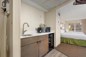 大洋城Americana Hotel Boardwalk的一个带水槽的厨房和一张位于客房内的床