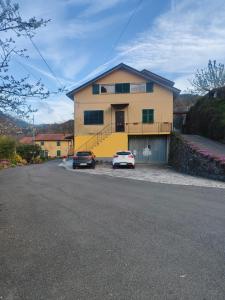 SovioreIl Giardino dei Pavoni的两辆汽车停在前面的黄色房子