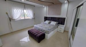 胡塞马Al Hoceima Ajdir Maroc - Maison 5 chambres 10 personnes的一间卧室设有一张床和一个窗口