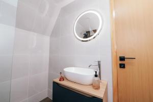 利夫诺Lake House Beliz的浴室设有白色水槽和镜子