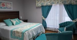 洛斯安赫莱斯Hotel Rarinco的一间卧室配有一张床和两张蓝色椅子