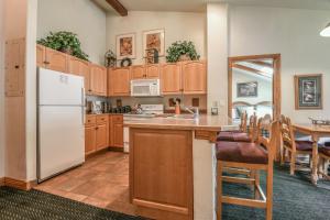 基斯通Hidden River Lodge 5995的厨房配有木制橱柜和白色冰箱。