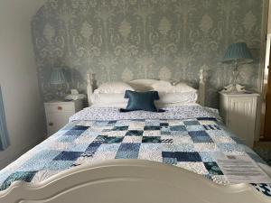 韦姆Abbey Green Farm的一间卧室配有一张带蓝色和白色被子的床