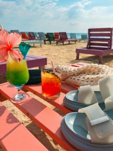 尼格瑞尔THE BOARDWALK VILLAGE的海滩上的一张桌子,上面摆放着盘子和饮料