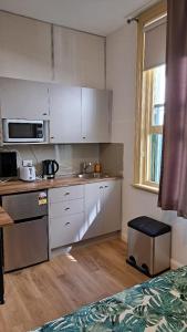 悉尼Randwick City Lodge 2的厨房配有白色橱柜和台面
