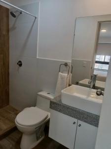 利马Massimo Apartament的白色的浴室设有卫生间和水槽。