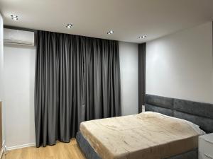 地拉那CozyStayApartments的一间卧室设有一张床和一个大窗户