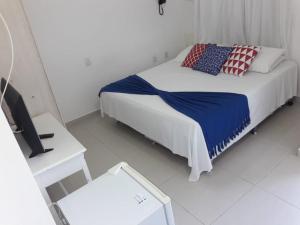 佩尼亚Hotel Maricá的一间白色卧室,配有床和电视