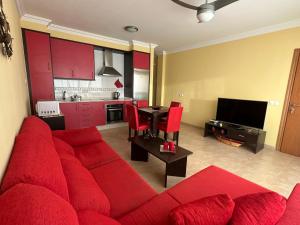 科蒂略Aguarii Cotillo的一间带红色沙发的客厅和一间厨房