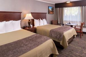 佩索罗伯斯Best Western Plus Black Oak的酒店客房设有两张床和一张桌子。
