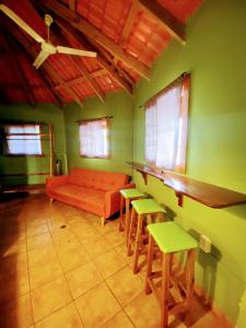 博卡斯德尔托罗Aqua Lounge Bar & Hostal的客厅配有橙色沙发和椅子
