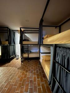 昆卡Ñañas Hostel的带两张双层床的客房,铺有砖地板