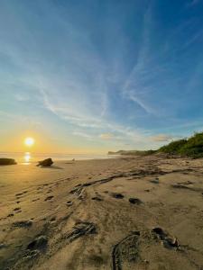 托拉Casa Mariposa的日落时在沙滩上留下脚印的海滩