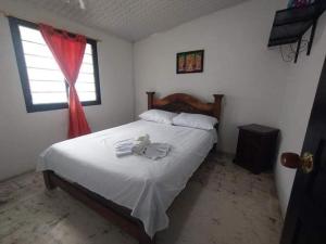 NorcasiaCasa Hostal M&M的一间卧室配有一张带白色床单的床和一扇窗户。
