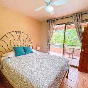 坦波Hotel Costa Coral的一间卧室配有一张带蓝色枕头的床和一扇窗户。