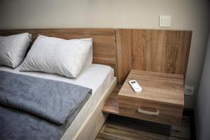ChortkivGreen Town Apartment的一间卧室配有一张床和一个带遥控器的床头柜。