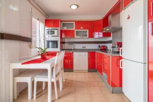 阿尔豪林格朗德Beautiful penthouse with spectacular views.的厨房配有红色橱柜和白色的桌椅