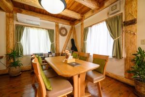 伊东貸別荘Clover　天城杉のログハウス　伊豆高原的一间带木桌和椅子的用餐室