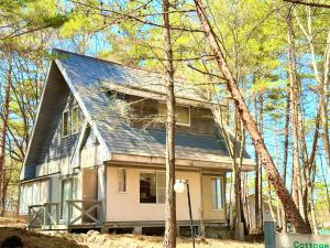 嬬恋村HOLIDAY VILLA Hotel & Resort KARUIZAWA的森林中间的小房子