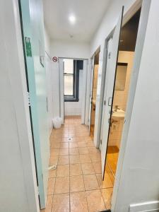 悉尼唐宁旅舍的浴室的走廊铺有瓷砖地板。