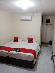 HaguVina Vira Hotel的宿舍间内的两张床,配有红色枕头