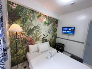 巴旺Generosa Beach Club的一间设有白色沙发和壁画的房间