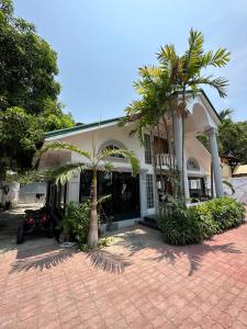 巴旺Generosa Beach Club的前面有棕榈树的房子