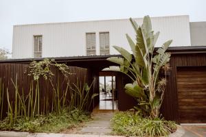 乌姆德洛蒂Maison De Plage的围栏前有棕榈树的房子