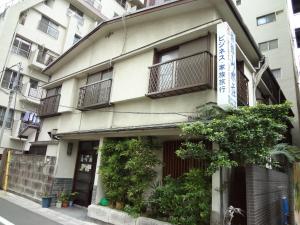 东京山水庄日式旅馆的街道上一座带阳台和植物的建筑