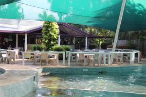 贾比鲁Aurora Kakadu Lodge的游泳池旁带桌椅的天井