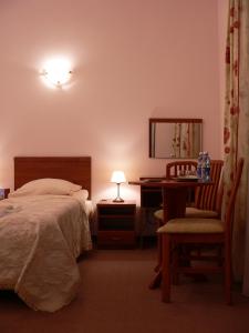 克雷尼察里拉宾馆的一间卧室配有一张床、一张桌子和一把椅子
