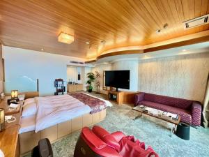 别府SKY Tower Sweet 4 Beppu, Resort Love Hotel的一间大卧室,配有一张大床和一张沙发