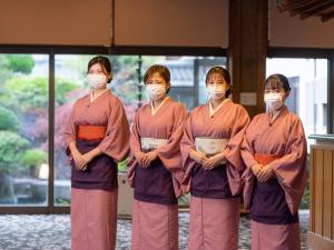 笛吹市甲子园铭庭日式旅馆的一群4名妇女戴面具在一座建筑物里