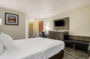 伊纳姆克洛Rodeway Inn Enumclaw Mount Rainer-Crystal Mountain Area的酒店客房配有一张床、一张书桌和一台电视。