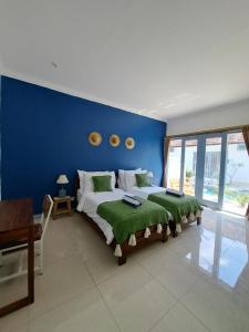 吉利特拉旺安Kubuwatu Boutique Accommodation的一间卧室设有一张蓝色墙壁的大床