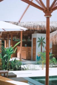 吉利阿尔My Island Home Gili Air的一个带游泳池和茅草屋顶的度假胜地