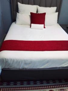 克莱克斯多普PS GOOD TIME GUEST HOUSE的一张铺有红白色床单和枕头的床