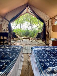 TandulujanggaCamp Tarimbang的帐篷配有两张床和一张桌子
