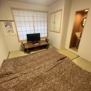 大阪茶隐の宿的一间带大床和电视的卧室