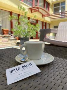 蒂豪尼Hello Balcsi Apartmanház的桌上的咖啡杯,上面有标志