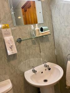 彭里斯Sunset House B&B的一间带水槽、镜子和卫生间的浴室