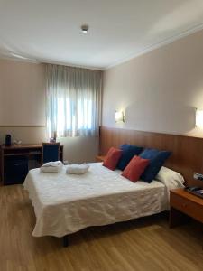 San Román安达穆圣罗曼酒店的一间卧室配有一张带蓝色和红色枕头的大床