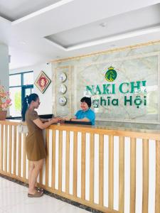 富国Nakichi Hotel Phú Quốc的站在餐厅柜台的女人