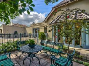 开普敦Villa Jesdene的一个带绿色长椅和桌子的庭院