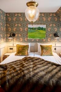 布勒萨普布罗萨捷斯提芙丽酒店暨SPA的卧室配有一张带吊灯的大型白色床。