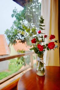 NambanLim Village - Nam Ban的一张桌子上装满红玫瑰的花瓶