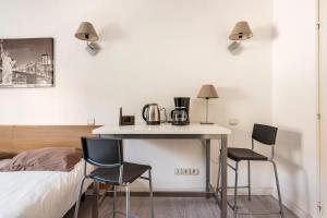 马赛马赛普拉多斐瑞尔公寓式酒店的一间卧室配有桌子、两把椅子和一张床